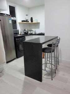 a kitchen with a black counter and a refrigerator at Flat recém-reformado e bem localizado in Vitória +30 photos