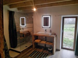 a bathroom with two sinks and a shower at Chambres d'hôtes Les cabris in Verneix