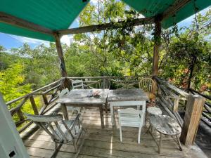 una mesa de madera y sillas en una terraza en Bahamian Farm House en Rock Sound