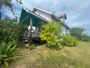 una casa rodeada de un porche en un jardín en Bahamian Farm House, en Rock Sound
