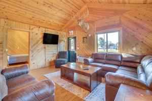 a living room with leather couches and a table at Black River Log Cabin Fish, Swim and Unwind! in Hatfield