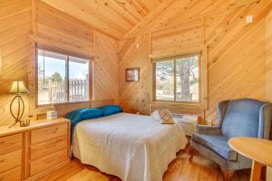1 dormitorio con 1 cama y 1 silla en una cabaña en Black River Log Cabin Fish, Swim and Unwind!, en Hatfield
