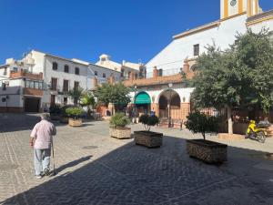 a man walking down a street with a cane at Patio de Los Barberos 3 in Valle de Abdalagís