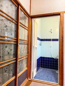 a bathroom with a shower with a glass door at Bighem Maison in Izumi-Sano