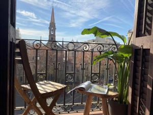 a balcony with a table and a book and a church at Luminous Designer Loft Style Apt Eixample Views By MyRentalHost in Barcelona