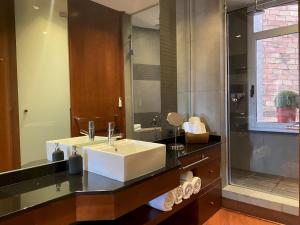 a bathroom with a white sink and a shower at Luminous Designer Loft Style Apt Eixample Views By MyRentalHost in Barcelona