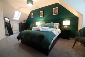 ein Schlafzimmer mit einem Bett mit einer grünen Wand in der Unterkunft Entire home in Llanfoist in Abergavenny