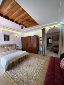 a bedroom with a large bed and a red rug at Maison d'h&ocirc;tes La Ferme AZIZA in F&egrave;s