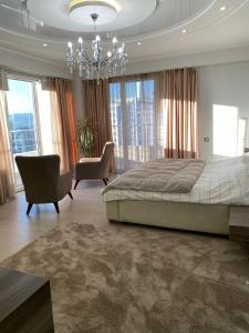 een slaapkamer met een groot bed en een kroonluchter bij Sweet home, 4 apartments in Doesjanbe