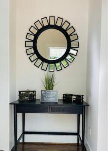 a black console table with a mirror on a wall at GROVE PARK- ‘Newly Renovated’ home- just mins from Midtown/Downtown Atlanta. in Atlanta