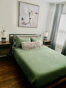 a bedroom with a bed with a green comforter at GROVE PARK- ‘Newly Renovated’ home- just mins from Midtown/Downtown Atlanta. in Atlanta