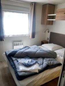 a bedroom with two beds and a window at Camping des Dunes de Contis mobilhome 3ch, in Saint-Julien-en-Born