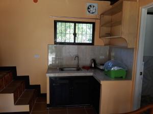 a small kitchen with a sink and a window at Gardenview Homestay Siargao in General Luna