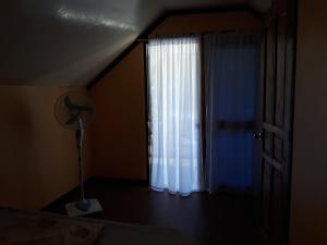 1 dormitorio con ventana y lámpara en una habitación en Gardenview Homestay Siargao, en General Luna