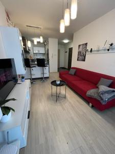 a living room with a red couch and a kitchen at AR LONDON HOUSE in Košice