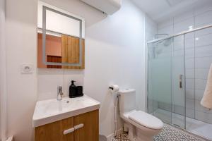 La salle de bains est pourvue de toilettes, d'un lavabo et d'une douche. dans l'établissement Les Maisons Acajou - Valenciennes, à Valenciennes