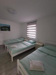 ein Zimmer mit drei Betten und einem Fenster in der Unterkunft Konak in Plav