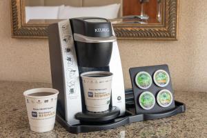 a coffee maker and two cups on a counter at Best Western Plus Waterbury - Stowe in Waterbury