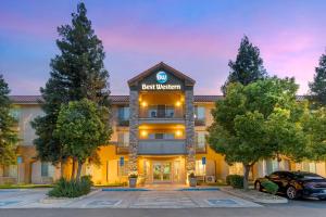 a best western hotel with a car parked in a parking lot at Best Western Visalia Hotel in Visalia