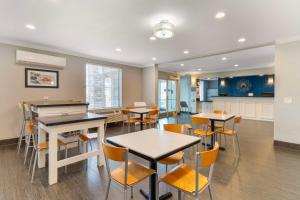 a room with tables and chairs and a kitchen at Best Western Visalia Hotel in Visalia