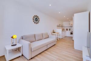 a living room with a white couch and a kitchen at Casa da Trindade Olhão - Boutique Collection in Olhão +21 photos