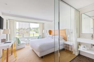プロエルメルにあるBest Western Plus Le Roi Arthur Hôtel & Spaのベッドとバスルーム付きのホテルルームです。