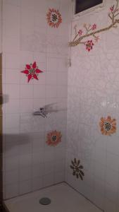 een badkamer met een douche met bloemen aan de muur bij MAISON AUGUY in Saint-Julien-Boutières