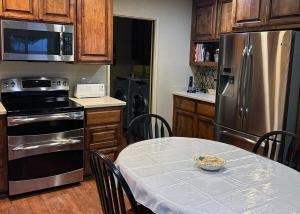 a kitchen with a table and a stainless steel refrigerator at Tomodachi House - The Perfect Getaway for All! in Davis