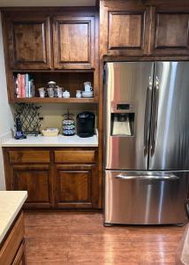 a kitchen with a stainless steel refrigerator and wooden cabinets at Tomodachi House - The Perfect Getaway for All! in Davis