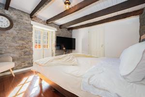 a bedroom with a large bed and a clock on the wall at Du.Val - Madeira Valley Villa in Ribeira Brava