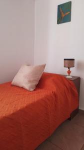 um quarto com uma cama com uma almofada e um candeeiro em Depto Viamonte - Planta Alta con Terraza y Cochera em Córdoba
