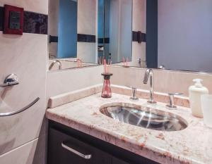 y baño con lavabo y espejo. en Depto Viamonte - Planta Alta con Terraza y Cochera en Córdoba