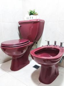 um WC vermelho e um bidé na casa de banho em Depto Viamonte - Planta Alta con Terraza y Cochera em Córdoba