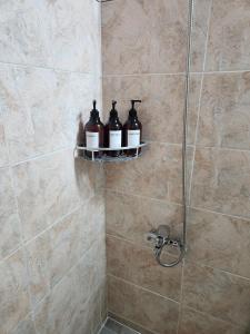 eine Dusche mit drei Flaschen auf einem Regal im Bad in der Unterkunft Stay Mido in Busan