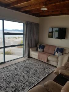 sala de estar con sofá y puerta corredera de cristal en Waitahanui Lodge, en Waitahanui