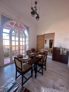 a dining room with a wooden table and chairs at Maison d'hôtes La Ferme AZIZA in Fès