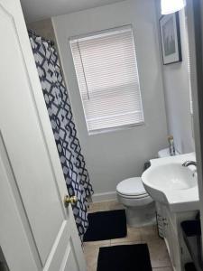 een badkamer met een toilet, een wastafel en een raam bij Townhouse in Hyattsville in Hyattsville