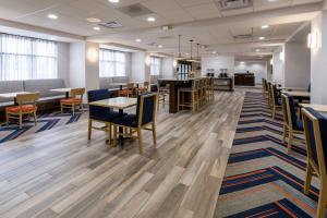 uma sala de espera vazia com mesas e cadeiras em Hampton Inn Milford em Milford