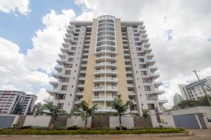 a tall building with palm trees in front of it at Kiluwa Apartments by Dunhill Serviced Apartments in Nairobi