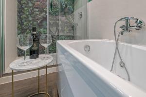 a bathroom with a tub and two wine glasses at Casa Gallo Firenze in Florence