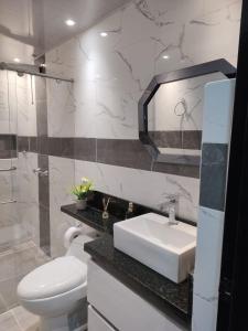 W łazience znajduje się umywalka, toaleta i lustro. w obiekcie Alquiler por días en Armenia Casahotel Villahermosa w mieście Armenia