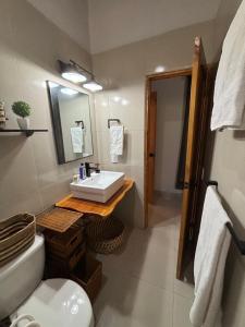 W łazience znajduje się umywalka, toaleta i lustro. w obiekcie La Quinta del Valle w mieście Llano Grande