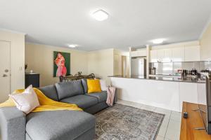 a living room with a couch and a kitchen at Albion Convenient Hideaway with Parking & Balcony in Brisbane