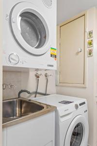 a kitchen with a washing machine and a sink at Albion Convenient Hideaway with Parking & Balcony in Brisbane