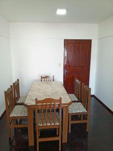 a dining room table with chairs and a wooden door at AMANDA in Ciudad del Este