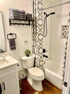 a white bathroom with a toilet and a shower at GROVE PARK- ‘Newly Renovated’ home- just mins from Midtown/Downtown Atlanta. in Atlanta