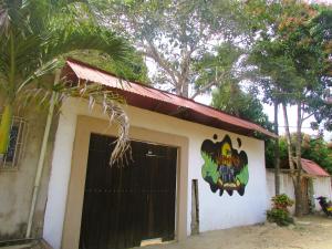 ein Gebäude mit einer schwarzen Tür mit einem Gemälde darauf in der Unterkunft Jumanji in Palomino