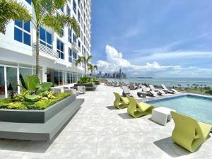 patio z krzesłami i basenem w obiekcie OlaMola City Apartment Panamá w Panamie
