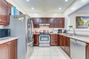 una cocina con armarios de madera y electrodomésticos de acero inoxidable en Avid vacation palace in Castlemore , Brampton, en Brampton