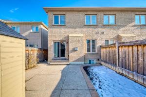 a brick house with a wooden fence in front of it at Avid vacation palace in Castlemore , Brampton in Brampton